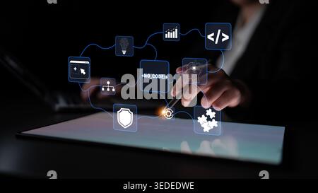 Hands interacting with a digital tablet showcasing no-code solution icons, representing modern technology, innovation, and digital transformation in a Stock Photo