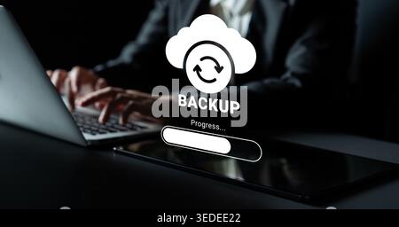 A focused scene depicting a cloud backup process with hands typing on a laptop, showcasing technology and data protection in a modern workspace Stock Photo