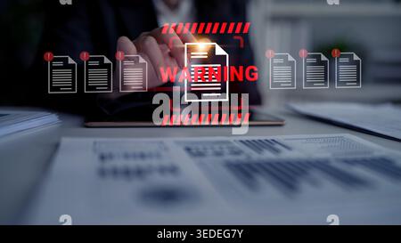A business person interacts with a digital tablet, showing a warning notice, surrounded by financial documents, emphasizing data management and Stock Photo