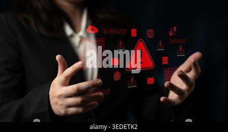 A business professional is visually presenting digital warning symbols and alerts, underscoring the critical importance of cybersecurity and data Stock Photo