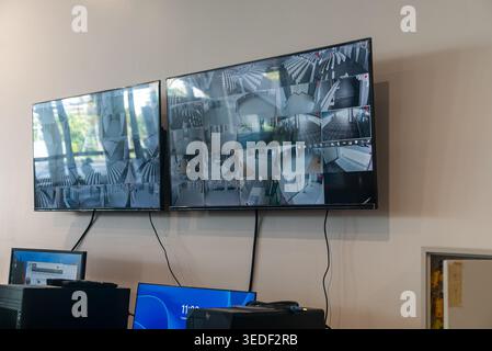 Two large screens displaying live feeds from surveillance cameras in a modern office setting, showcasing a tech-savvy workspace focused on security an Stock Photo