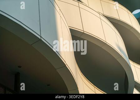 Close-up view of a modern architectural design showcasing curved lines and geometric shapes. The interplay of light and shadow highlights the innovati Stock Photo