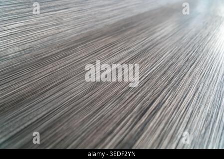 A captivating close-up of a metallic texture showcasing elegant linear patterns. The artwork highlights the interplay of light and shadow, creating a Stock Photo