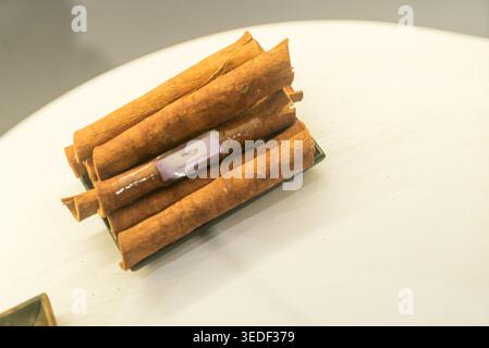 A collection of aromatic cinnamon sticks arranged beautifully on a white surface, showcasing the natural texture and earthy tones of this popular spic Stock Photo