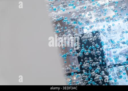 This abstract image showcases a captivating display of blue and transparent bubbles, creating a dynamic and modern atmosphere perfect for science-them Stock Photo