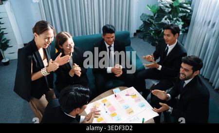 Top view of business people putting hands together and clapping hands to celebrate successful project while using kanban task board to manage time Stock Photo