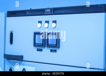 Modern electrical control panel features digital displays and control buttons, ideal for monitoring and managing industrial power systems and machiner Stock Photo