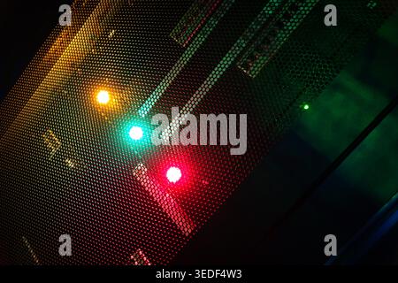 This artistic photograph showcases colorful traffic lights peeking through a mesh screen, creating a vibrant interplay of colors and patterns in an ur Stock Photo