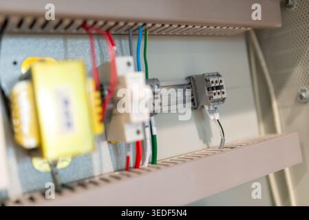 Close-up view of essential electrical components inside a control panel, showcasing wiring, connections, and safety features in an industrial setup. Stock Photo