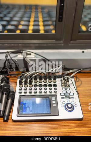 A modern audio mixer sits atop a polished surface, featuring various controls and inputs. Ideal for professional sound mixing, recording, and broadcas Stock Photo