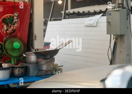 A vibrant street food stall featuring cooking equipment including a wok, pots, and utensils. The scene captures the essence of local culinary culture Stock Photo