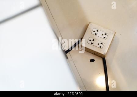 A close-up view of a wall socket with multiple plugs and cables. This image highlights the essential electrical connection in a modern home or office Stock Photo