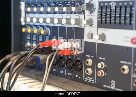 Close-up view of an audio mixer board displaying various knobs and connectors, highlighting the intricate details of sound equipment and audio connect Stock Photo