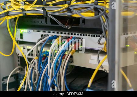 A close-up view of network equipment showcasing colorful cables. The scene highlights the intricacies of data transmission and connectivity in a serve Stock Photo