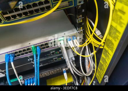 Close-up view of a network switch displaying various connections and cables, showcasing the intricate setup of a modern data communication infrastruct Stock Photo