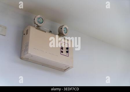This image shows a vintage air conditioning unit mounted on a wall, showcasing a unique retro design ideal for home settings and renovation projects. Stock Photo