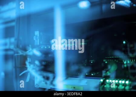 A captivating view of a server room with glowing blue lights and intricate cables. The image showcases advanced technology and modern infrastructure i Stock Photo