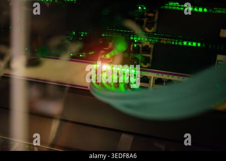 A close-up view of illuminated network cables in a data center, showcasing advanced technology and network connections that power modern communication Stock Photo