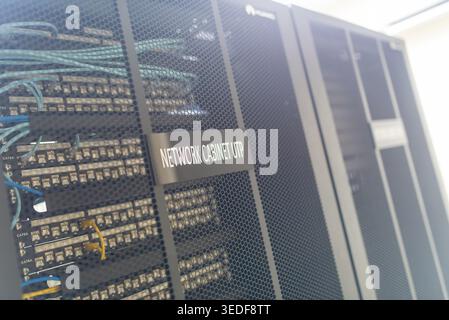 A close-up view of a network cabinet showing organized cables and essential equipment, showcasing modern technology in a data center environment. Stock Photo