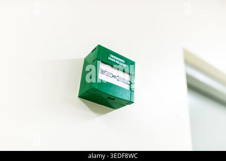 Green emergency door alarm signal box mounted on the wall, providing crucial safety alerts in case of emergencies, enhancing security and preparedness Stock Photo