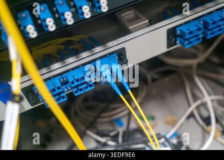 Close-up view of fiber optic cables properly connected in a data center. The image showcases connectivity and technology setup for efficient data tran Stock Photo