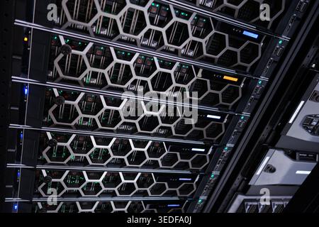 A modern data center showcasing server racks illuminated by various colored lights. The image exemplifies high-performance computing technology and ef Stock Photo