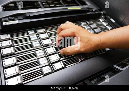 A close-up view of a hand interacting with server components in a modern data center. This image showcases the technology and operation within a high- Stock Photo
