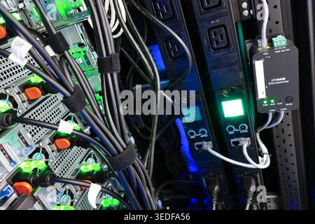 Close-up view of a high-tech server rack showcasing cables, connectors, and control panels. Ideal for technology, IT, and engineering themes. Stock Photo