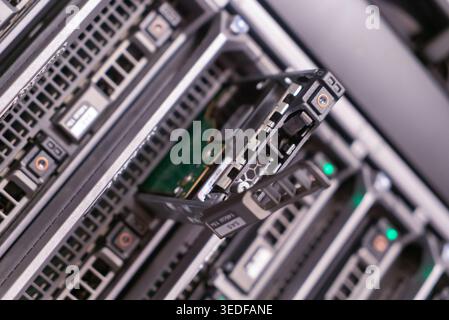 Close-up of a server storage array featuring a hard drive being installed. The image illustrates the intricate technology behind data management and s Stock Photo