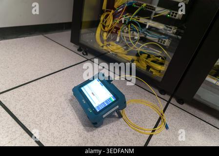 A fiber optic testing device is showcased in a modern data center, highlighting the significance of testing tools for network performance and installa Stock Photo