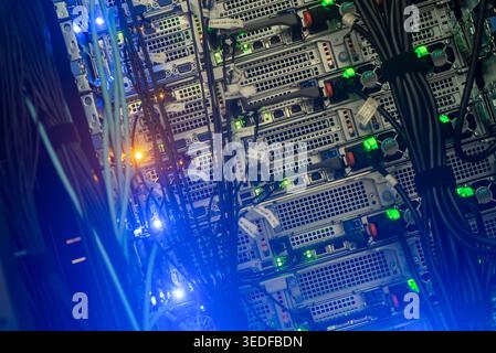 Close-up view of a server rack showing colorful lights and tangled cables, highlighting the complexity and technology of modern data centers and netwo Stock Photo