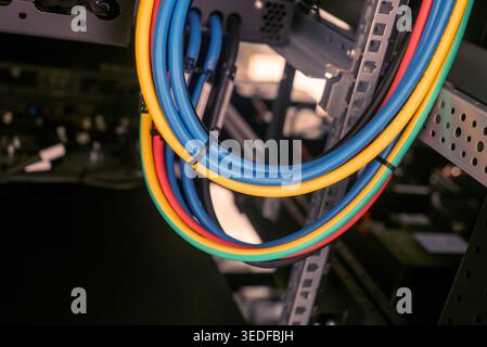 Close-up shot of colorful cables organized in a server rack, showcasing efficient data management and modern technology in a professional IT environme Stock Photo