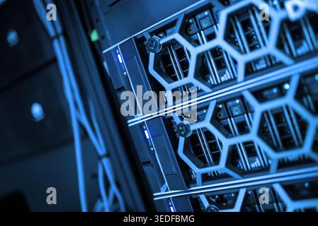 Close-up view of modern server equipment in a data center showcasing intricate technology design with blue lighting and cables, emphasizing computing Stock Photo