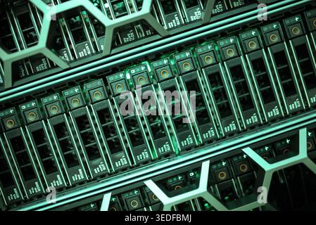 Explore a detailed view of advanced data storage systems featuring glowing green lights and organized hardware components, showcasing modern technolog Stock Photo