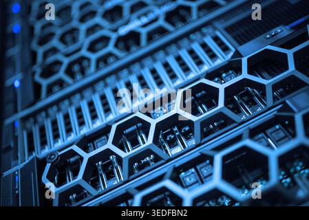 High-tech server rack showcasing advanced technology with blue lighting. This image highlights the intricate details and organization of modern server Stock Photo