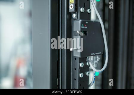 This close-up image showcases advanced network equipment within a server room, highlighting essential connections and technology for efficient data ma Stock Photo