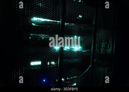 A close-up view of a computer server rack illuminated with glowing indicators, showcasing modern technology and digital infrastructure in a server roo Stock Photo