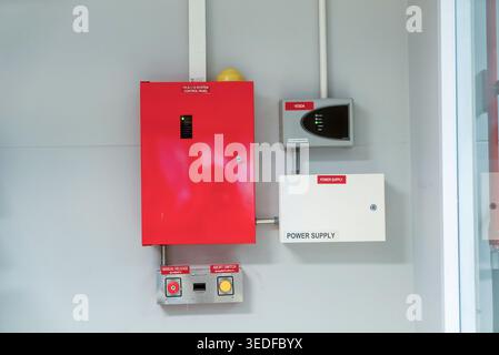 The image showcases a red fire alarm control panel and a power supply unit on a wall, highlighting essential safety equipment for emergency response i Stock Photo