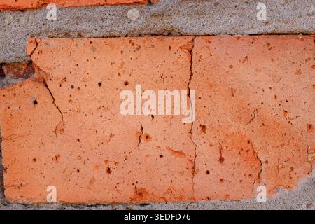 Cracked red brick texture macro, old wall building material background Stock Photo