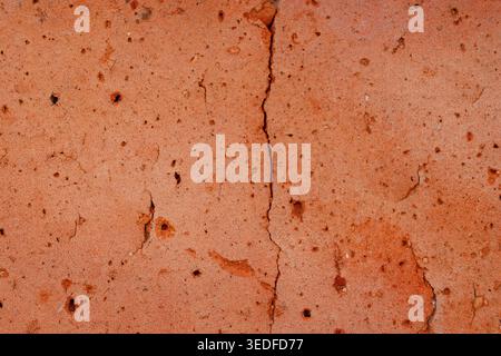 Red brick macro texture with vertical crack, porous building material Stock Photo