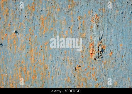 Cracked blue paint on rusty metal texture, peeling surface with heavy corrosion Stock Photo