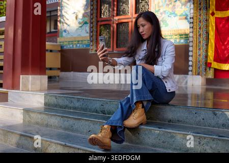 Casual pose of girl with phone on stone steps Stock Photo