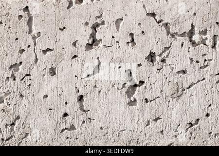 Grey concrete wall texture with deep holes and rough porous surface background Stock Photo