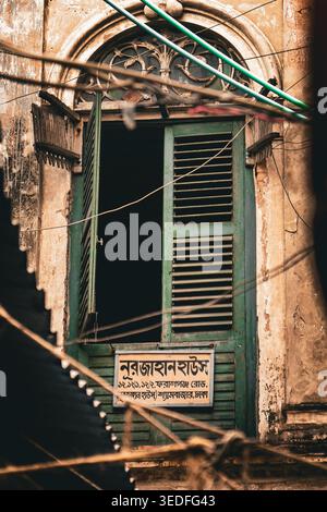A view of the weathered green wooden shutters and arched masonry of the historic Nurjahan House in Old Dhaka, Bangladesh, taken on May 13, 2023. Stock Photo