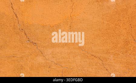 Orange plaster wall texture with cracks, rough stucco background Stock Photo