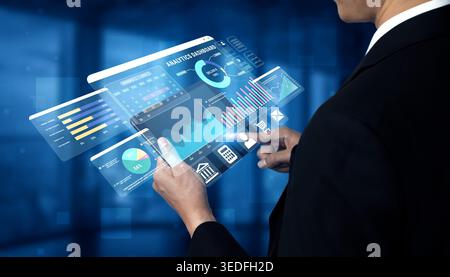 Business professional interacting with futuristic digital analytics dashboard showcasing various graphs and metrics in a modern office environment Stock Photo