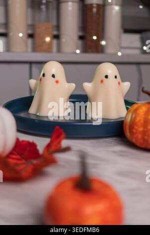 Cute ghost decorations on blue tray with mini pumpkins in festive autumn setting Stock Photo
