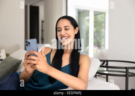 Pretty woman using smartphone gadget at home Stock Photo