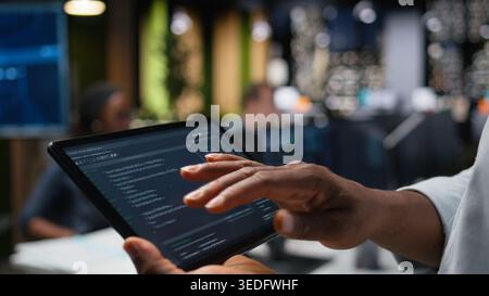 Close up of IT specialist using tablet in office, working with programming languages. Programmer using device in company workplace to do hardware systems quality assurance Stock Photo
