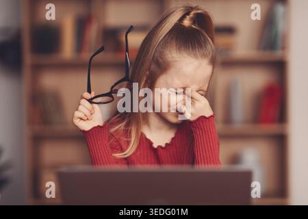 Girl Showing Signs of Frustration While Working on a Computer at Home in the Evening Stock Photo